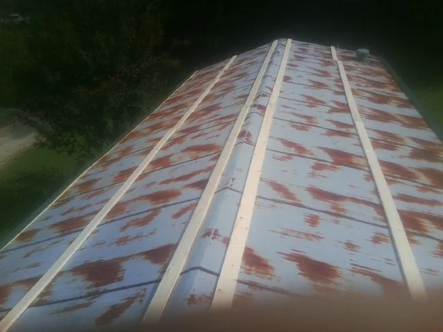 Rusted metal roof panels with new wood purlins before replacement — Storm Damage Roof Repair in Castle Rock by Roofing Brothers